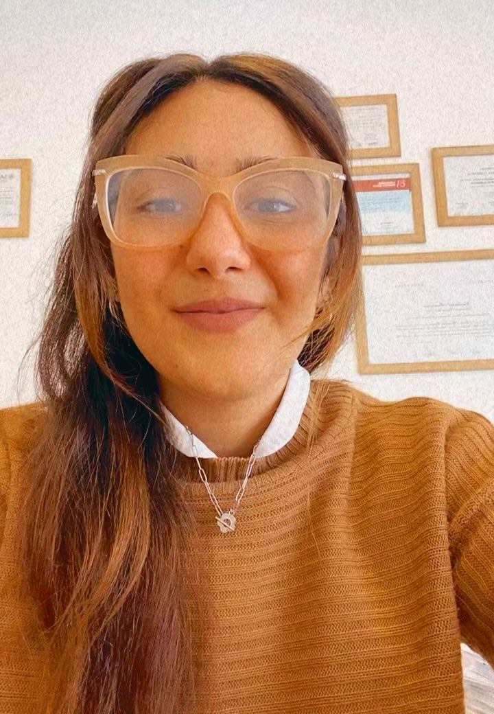 Flor en su consultorio, con los diplomas en la pared