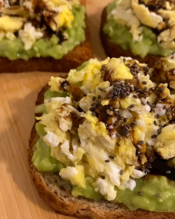 Tostadas de pan integral con mayonesa de palta, huevos revueltos y semillas, foto de Flor
